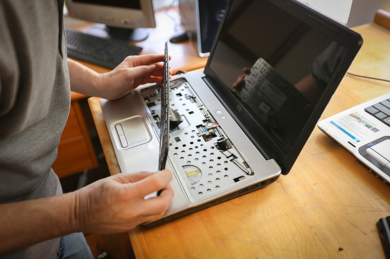 Image of a tech removing and performing a laptop keyboard repair